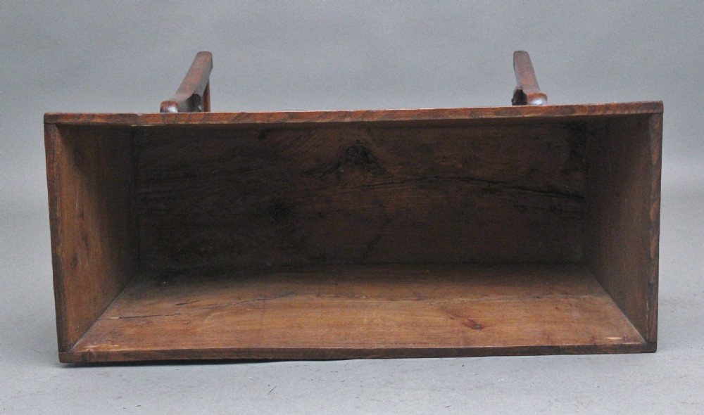 An 18th-century elm dough bin with a flat rectangular lid resting on a four-legged timber stand. View IX