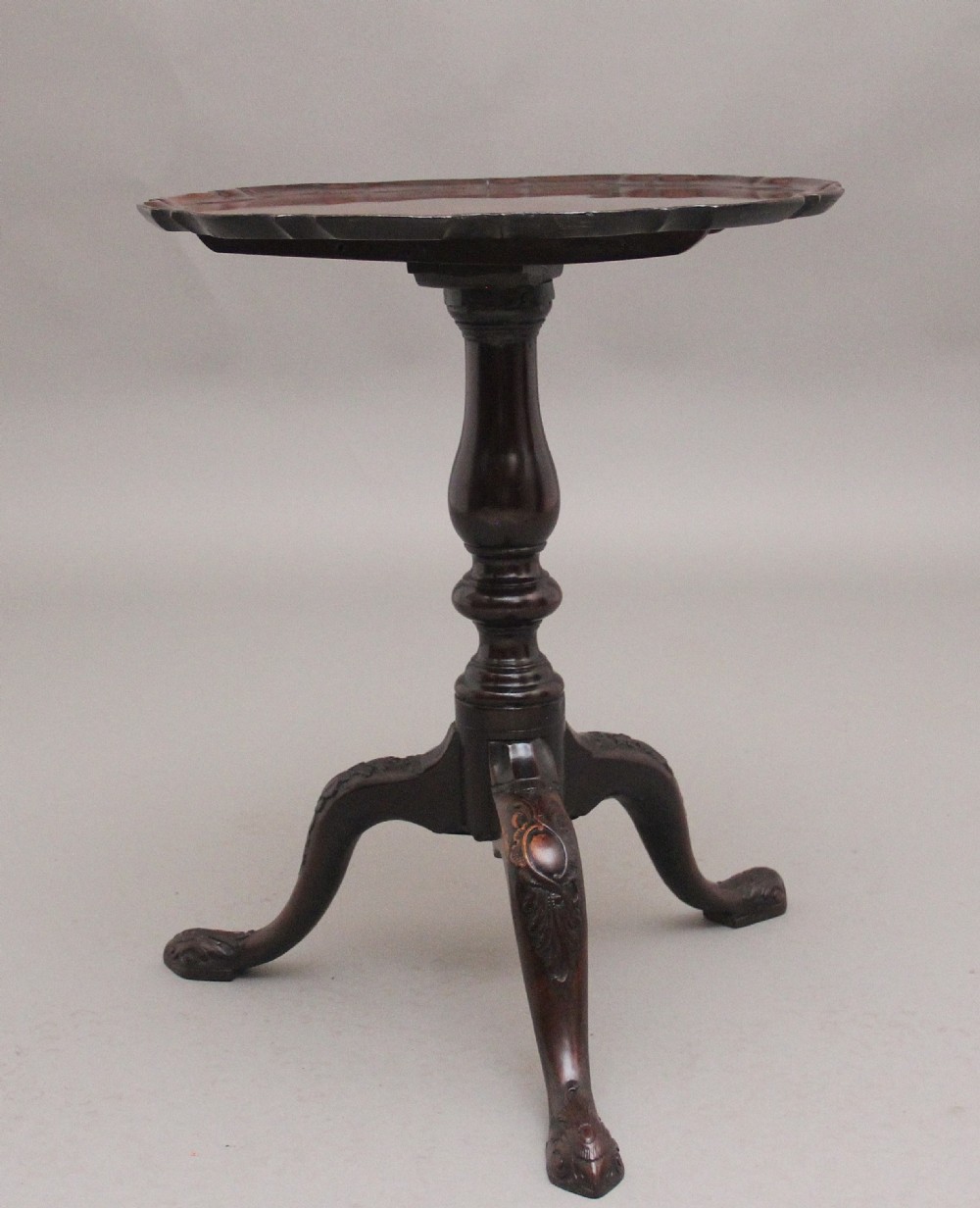 An 18th-century dark mahogany tripod table with a carved scalloped edge shown with its top tilted vertically on a turned pedestal stem. View III