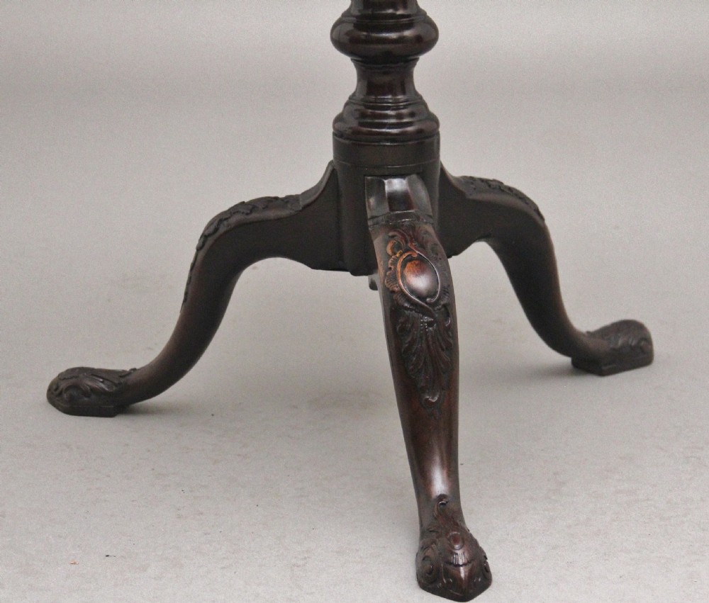 An 18th-century dark mahogany tripod table with a carved scalloped edge shown with its top tilted vertically on a turned pedestal stem. View IX