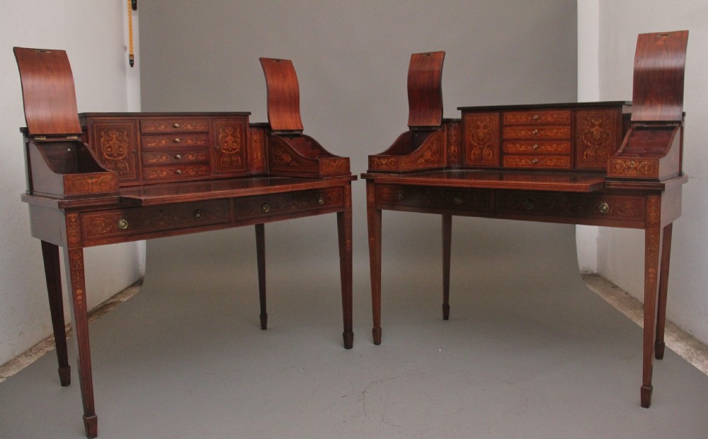 A pair of early 20th-century mahogany Carlton House desks with detailed satinwood marquetry inlay, stepped gallery drawers, and tapered legs. View III