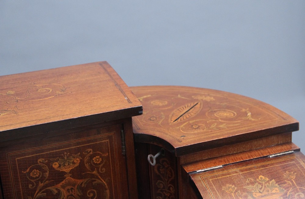 A pair of early 20th-century mahogany Carlton House desks with detailed satinwood marquetry inlay, stepped gallery drawers, and tapered legs. View XV