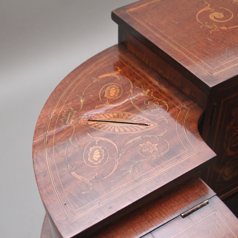 A pair of early 20th-century mahogany Carlton House desks with detailed satinwood marquetry inlay, stepped gallery drawers, and tapered legs. View XXVI
