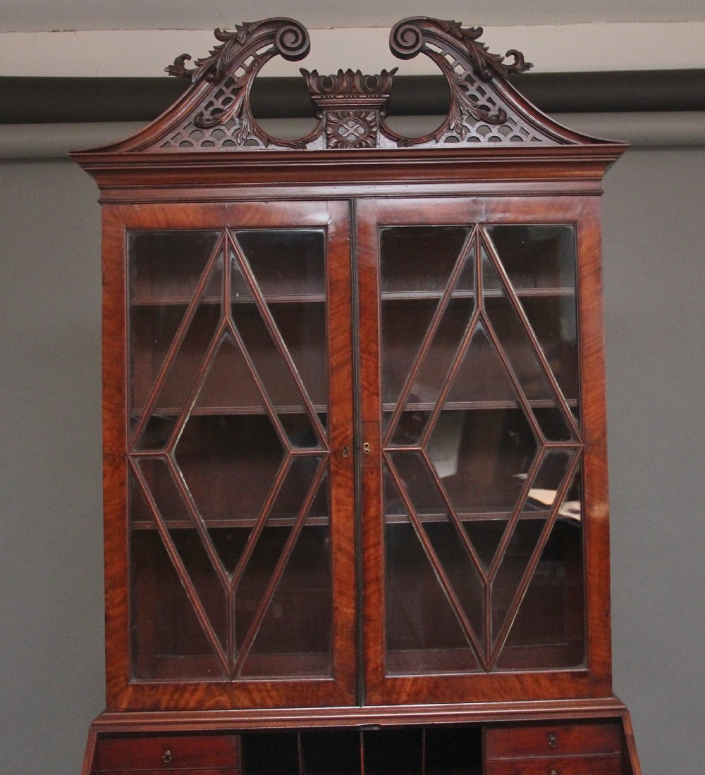 An early nineteenth-century mahogany bureau bookcase featuring a swan-neck pediment, diamond astragal glazed upper doors, a slant-front writing flap, and four graduated drawers. View IV