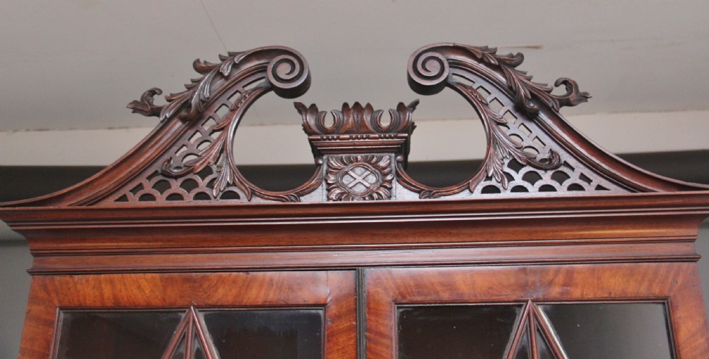 An early nineteenth-century mahogany bureau bookcase featuring a swan-neck pediment, diamond astragal glazed upper doors, a slant-front writing flap, and four graduated drawers. View XI