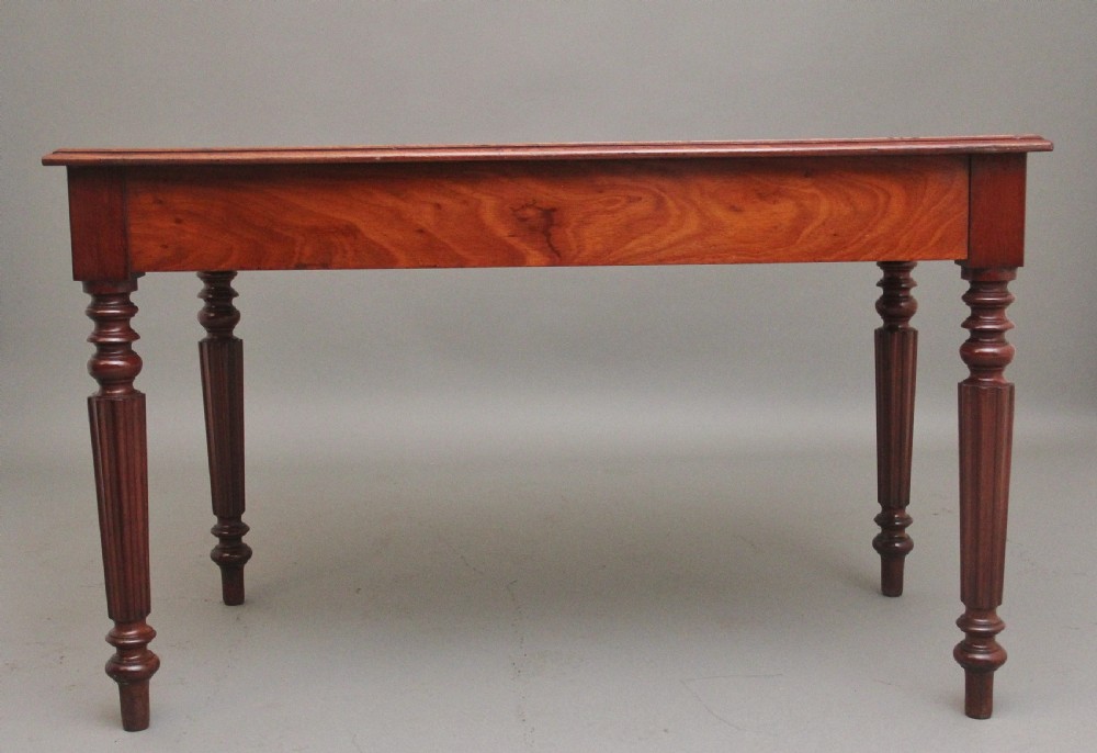 A 19th-century mahogany writing table featuring two frieze drawers with brass ring drop handles, supported by four turned and reeded legs. View VI