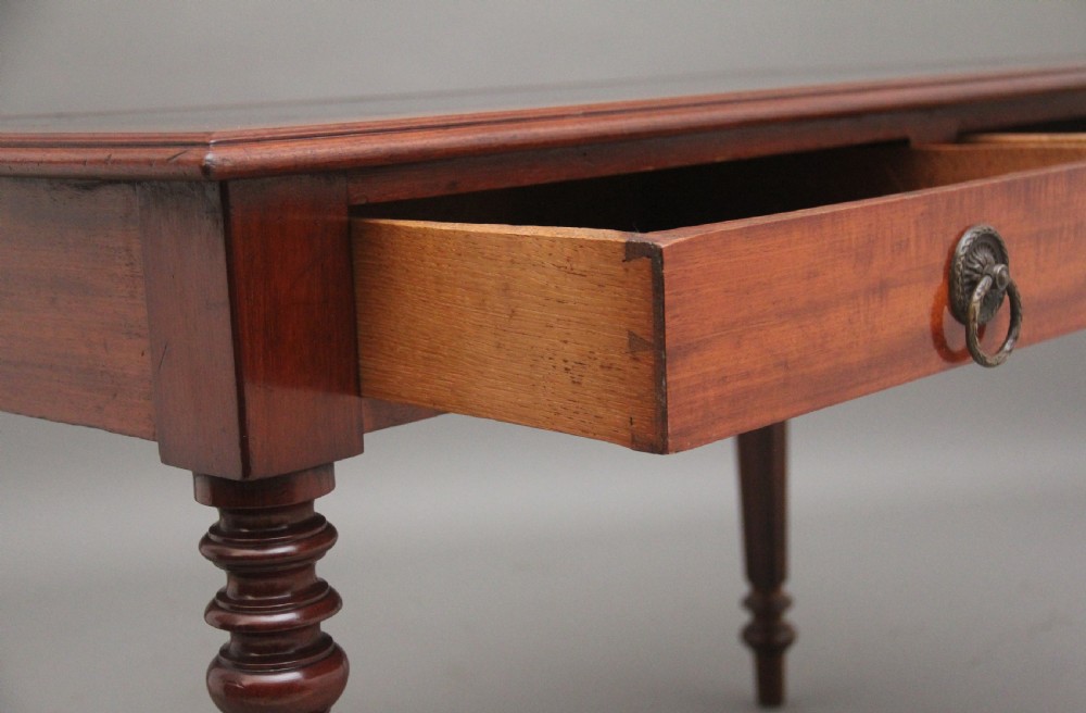 A 19th-century mahogany writing table featuring two frieze drawers with brass ring drop handles, supported by four turned and reeded legs. View IX