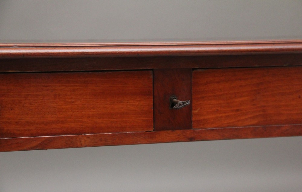 A 19th-century mahogany writing table featuring two frieze drawers with brass ring drop handles, supported by four turned and reeded legs. View XII