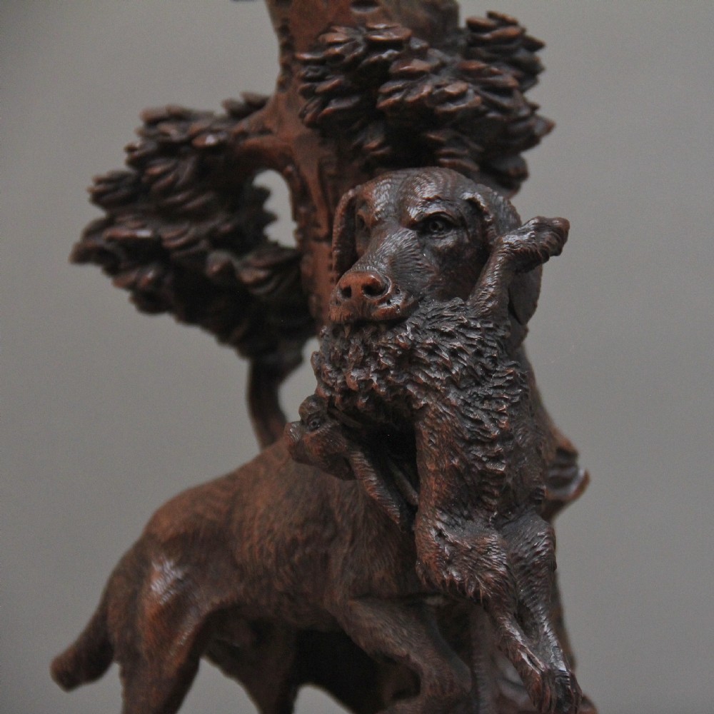 A nineteenth-century carved dark wood Black Forest centrepiece featuring a hunting dog holding game beneath a clear cut-glass trumpet vase. View X
