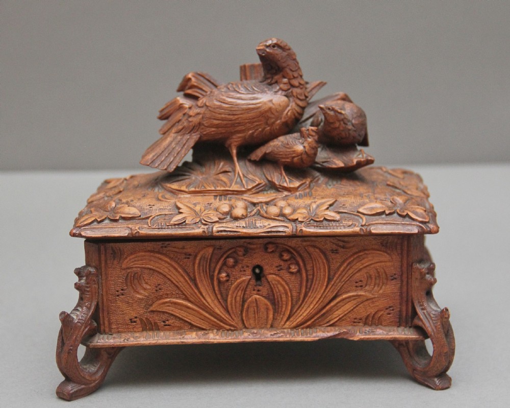 A 19th-century carved walnut casket featuring a game bird figure sculpted on the hinged lid and foliate scroll feet. View VI