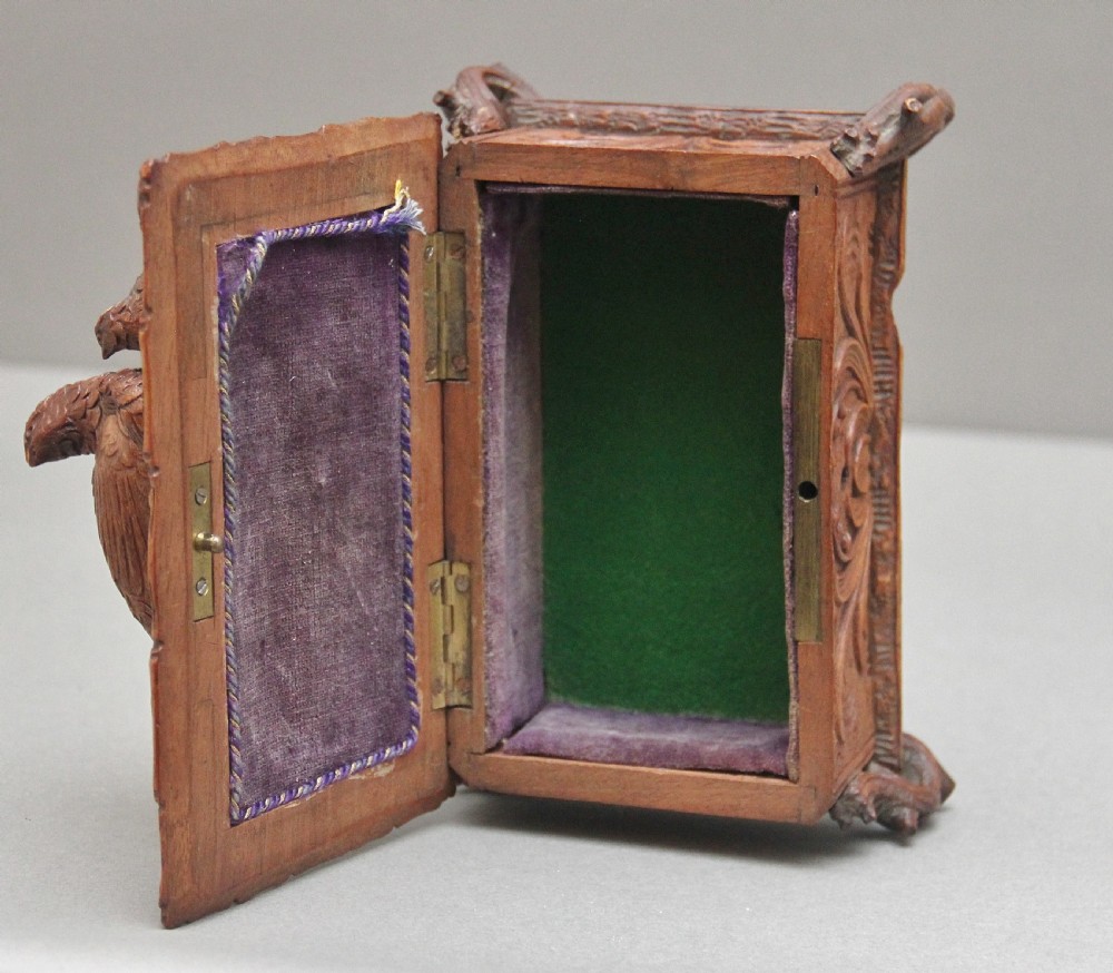 A 19th-century carved walnut casket featuring a game bird figure sculpted on the hinged lid and foliate scroll feet. View VIII