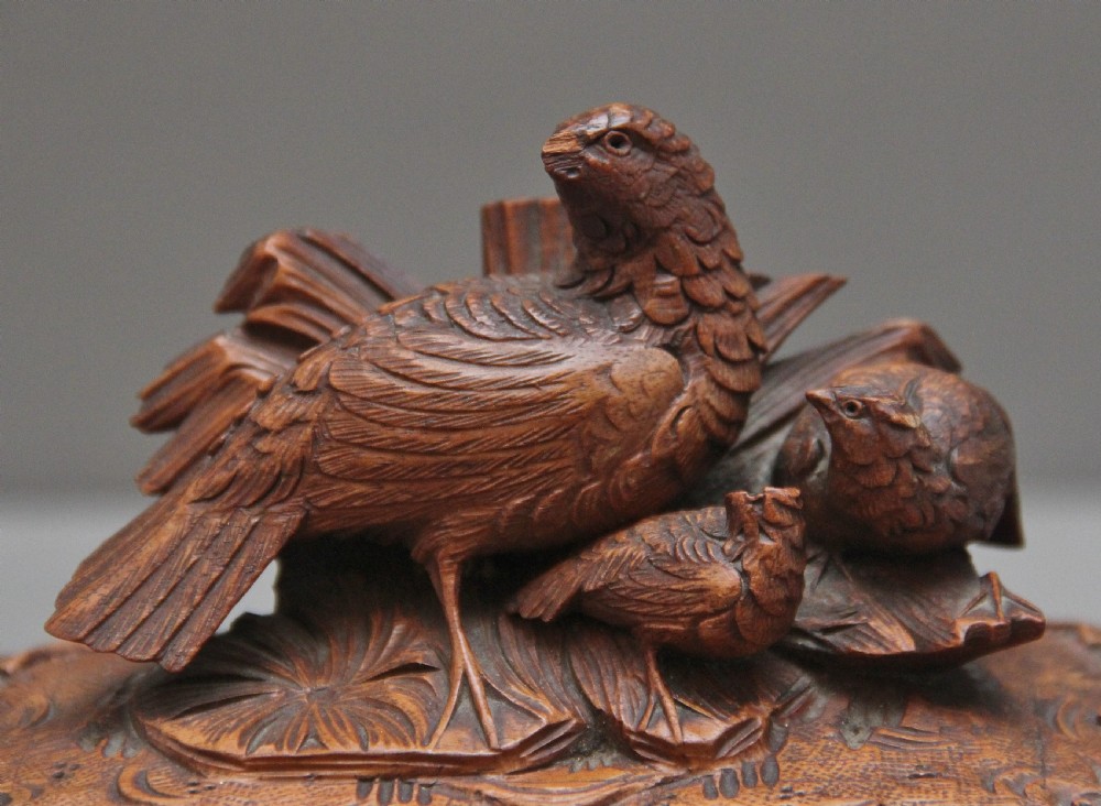 A 19th-century carved walnut casket featuring a game bird figure sculpted on the hinged lid and foliate scroll feet. View IX