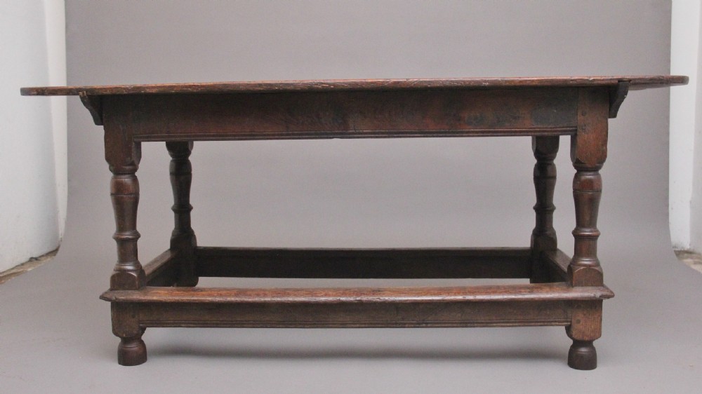 A 17th-century oak refectory table featuring a plank top, turned legs, and a perimeter box stretcher base. View IV