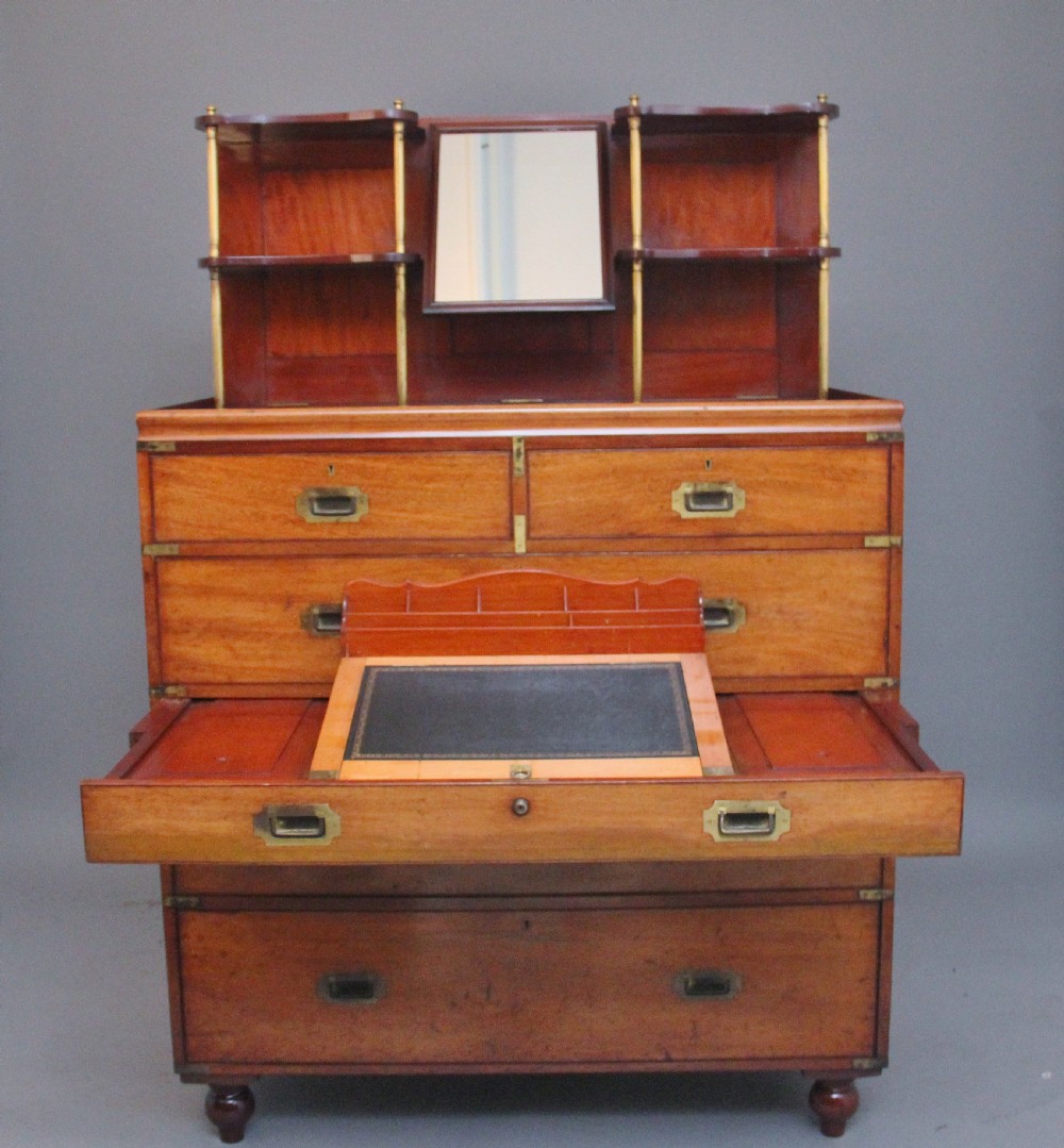 A 19th-century mahogany campaign chest of drawers featuring brass corner brackets, flush brass handles, turned feet, and an upper shelf superstructure with a central mirror. View III