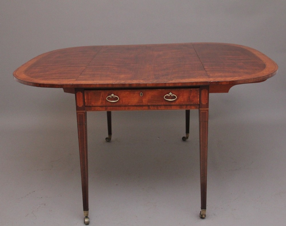 An early 19th-century inlaid mahogany Pembroke table with rounded drop leaves, a single frieze drawer, tapered legs, and brass castors. View VIII