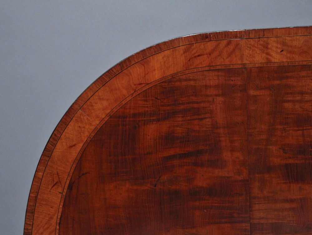 An early 19th-century inlaid mahogany Pembroke table with rounded drop leaves, a single frieze drawer, tapered legs, and brass castors. View XIII