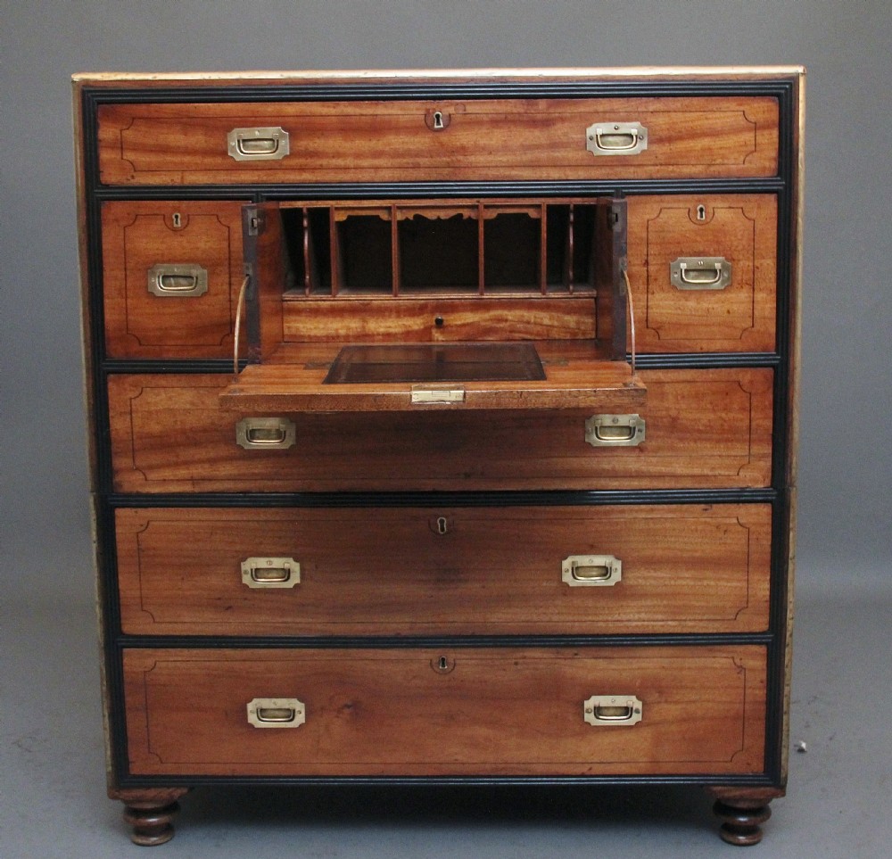 A 19th-century camphor wood military campaign chest featuring brass corner mounts, flush handles, ebonised drawer surrounds, and turned feet. View II