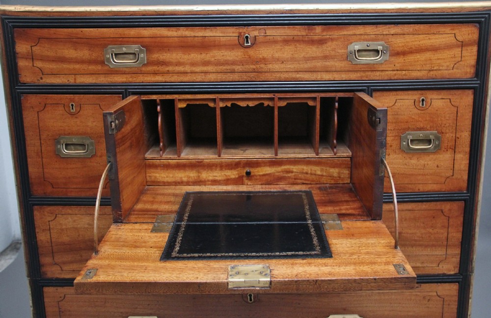 A 19th-century camphor wood military campaign chest featuring brass corner mounts, flush handles, ebonised drawer surrounds, and turned feet. View III