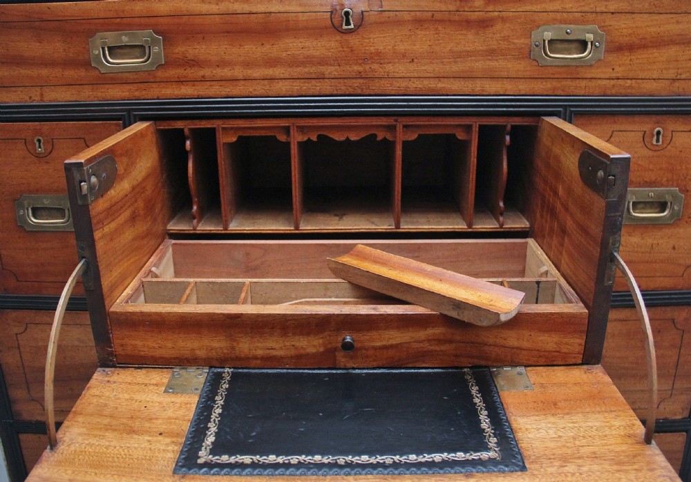 A 19th-century camphor wood military campaign chest featuring brass corner mounts, flush handles, ebonised drawer surrounds, and turned feet. View VII