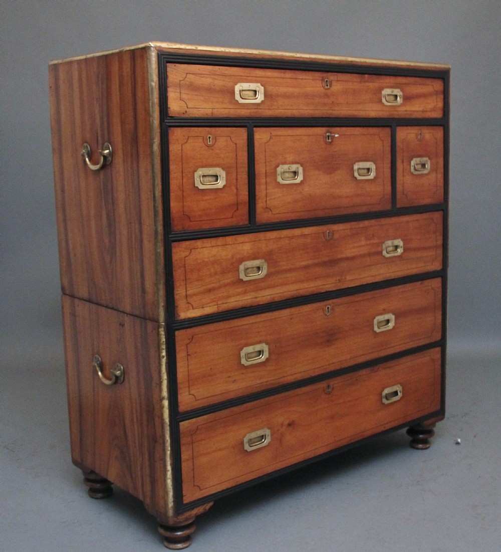 A 19th-century camphor wood military campaign chest featuring brass corner mounts, flush handles, ebonised drawer surrounds, and turned feet. View IX