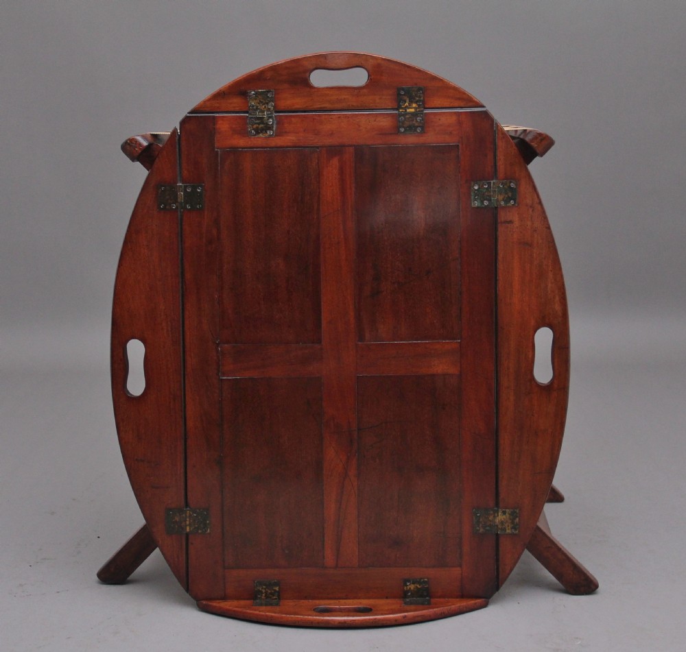 A 19th-century mahogany butler tray featuring shaped gallery sides with cutout handles resting upon a collapsible X-frame stand with webbing straps. View XI