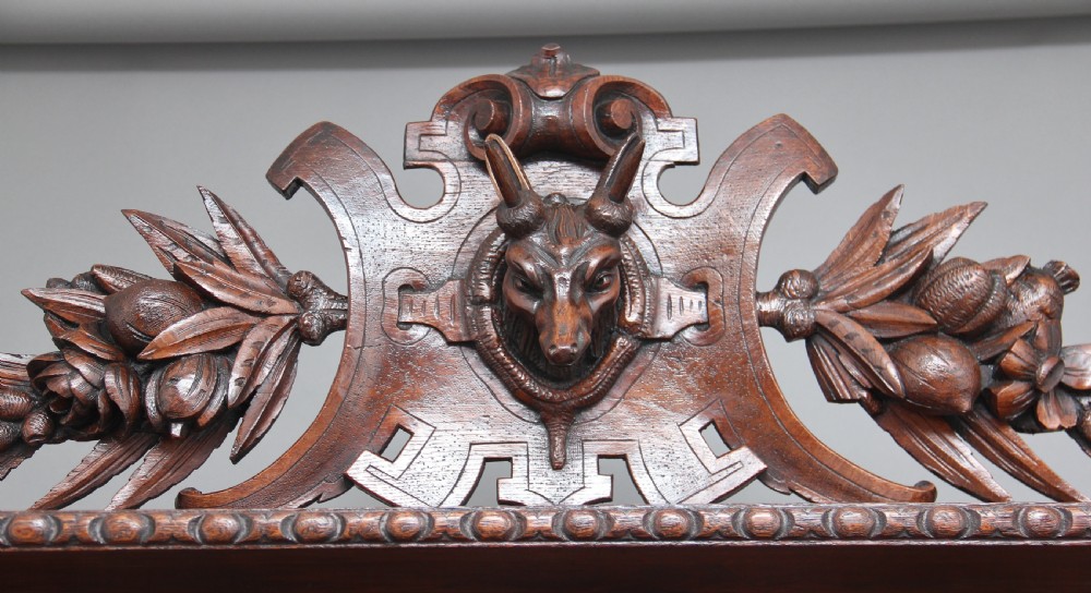 A 19th-century dark oak two-tiered buffet featuring intricate hand-carved reliefs of game, foliage, and a prominent stag head cresting. View VI