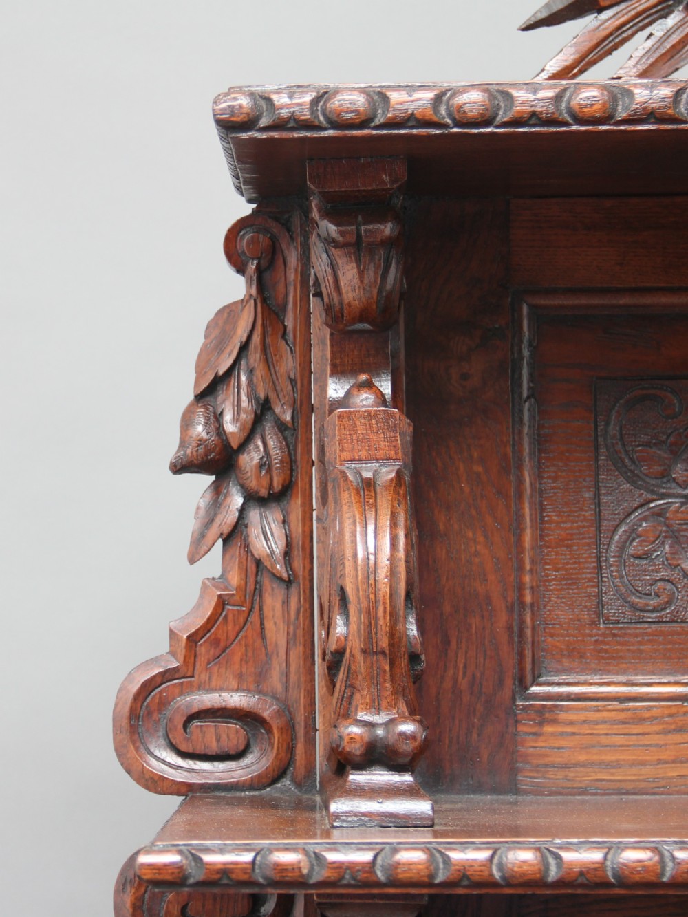 A 19th-century dark oak two-tiered buffet featuring intricate hand-carved reliefs of game, foliage, and a prominent stag head cresting. View XVII