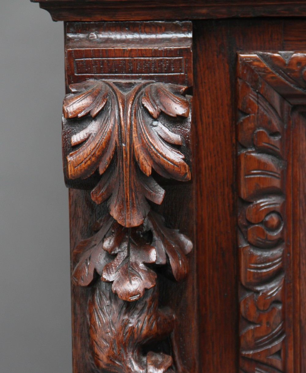 A 19th-century dark oak two-tiered buffet featuring intricate hand-carved reliefs of game, foliage, and a prominent stag head cresting. View XVIII