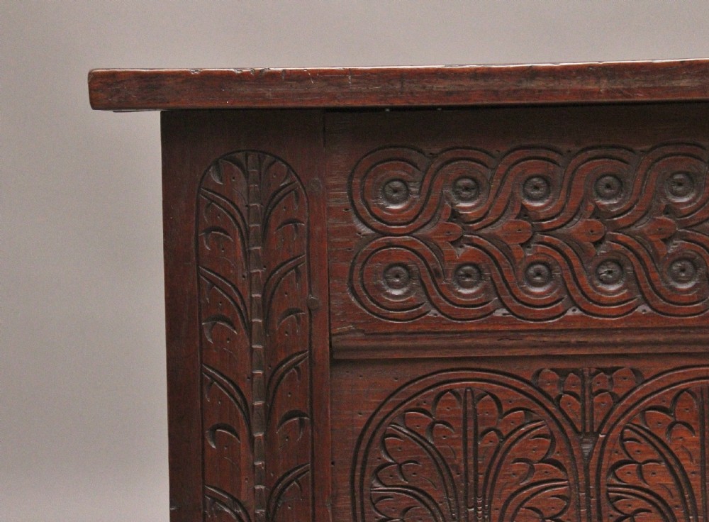 An 18th-century dark carved oak mule chest featuring intricate geometric panel carvings, a central iron lockplate, and a single lower drawer. View III