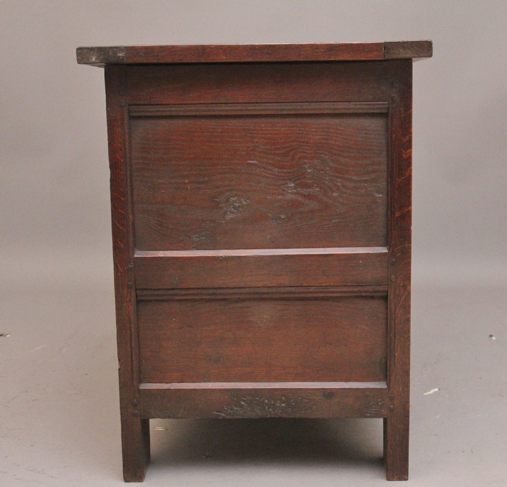 An 18th-century dark carved oak mule chest featuring intricate geometric panel carvings, a central iron lockplate, and a single lower drawer. View VIII
