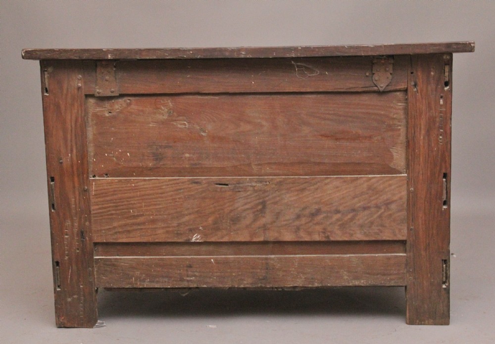 An 18th-century dark carved oak mule chest featuring intricate geometric panel carvings, a central iron lockplate, and a single lower drawer. View IX
