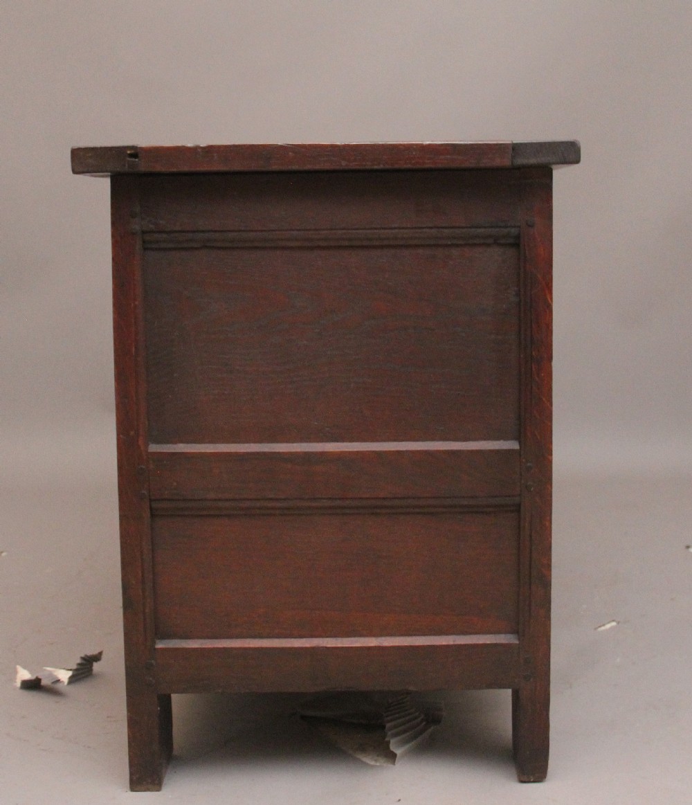 An 18th-century dark carved oak mule chest featuring intricate geometric panel carvings, a central iron lockplate, and a single lower drawer. View X