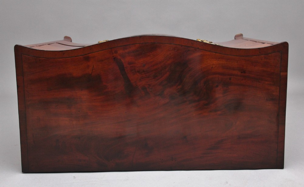 An 18th-century Georgian mahogany chest of drawers with a serpentine front, four graduated drawers, circular brass ring handles, a pull-out brushing slide, and bracket feet. View III