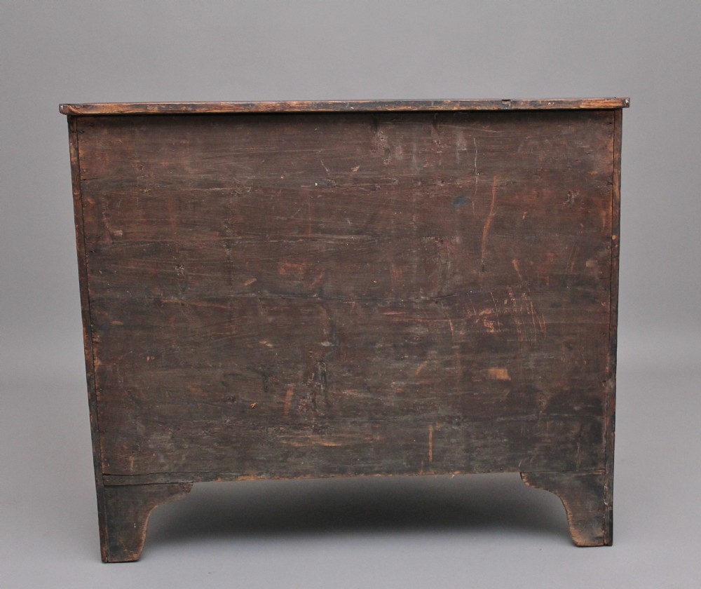 An 18th-century Georgian mahogany chest of drawers with a serpentine front, four graduated drawers, circular brass ring handles, a pull-out brushing slide, and bracket feet. View VIII