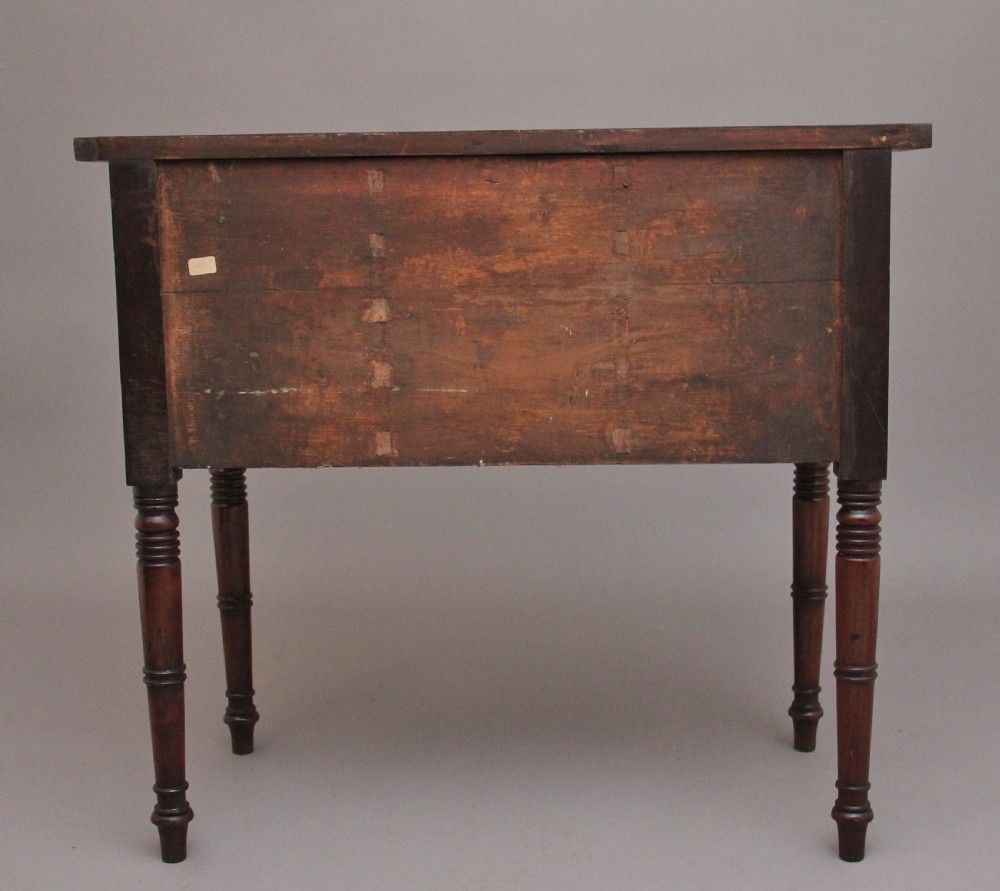 An early 19th-century bowfront mahogany sideboard with turned legs, brass ring drop handles, and central arch drawer. View VIII