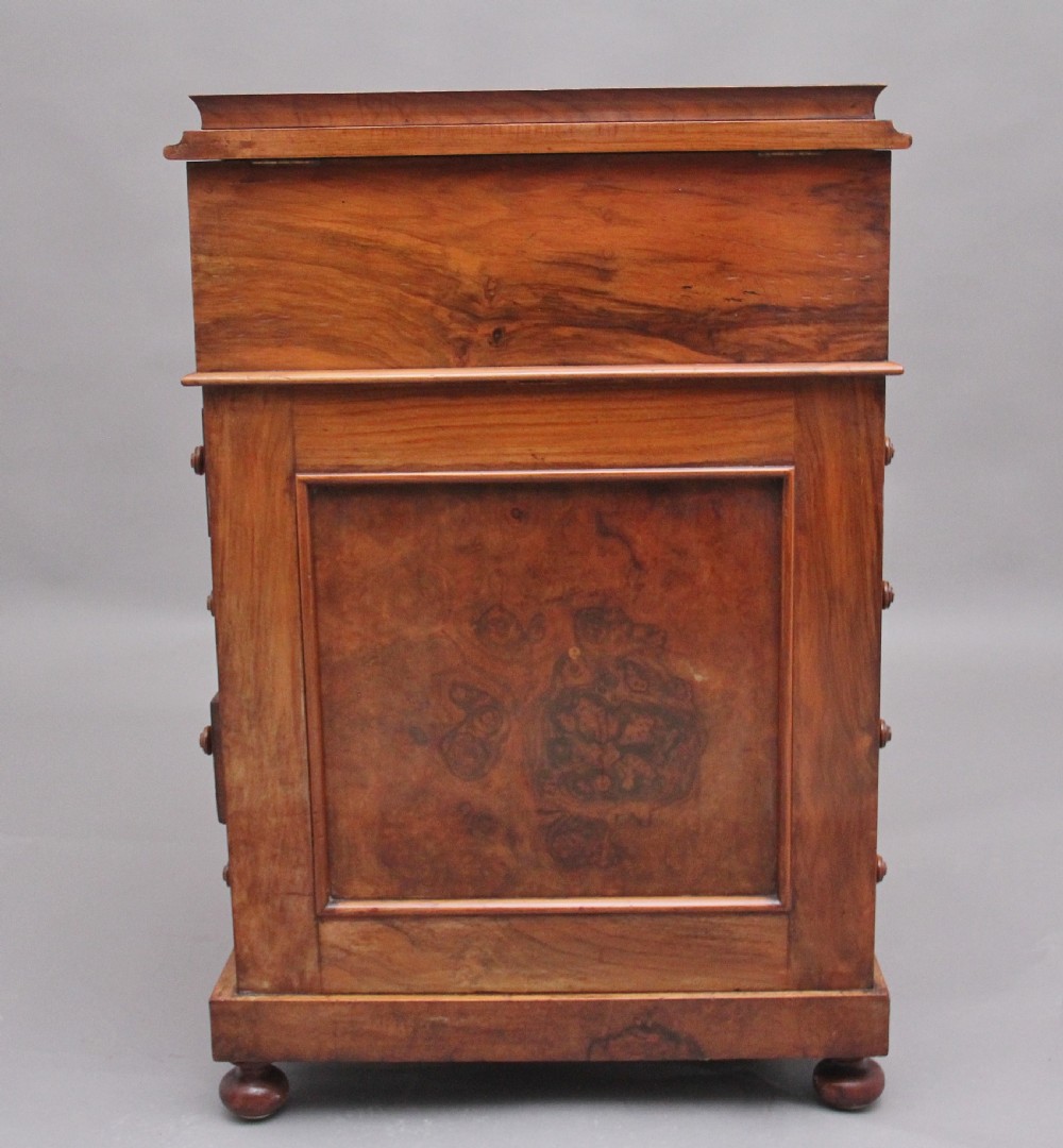 A 19th-century burr walnut Davenport desk featuring a sloped leather writing surface, side drawers with turned knobs, and carved decorative brackets. View XIII