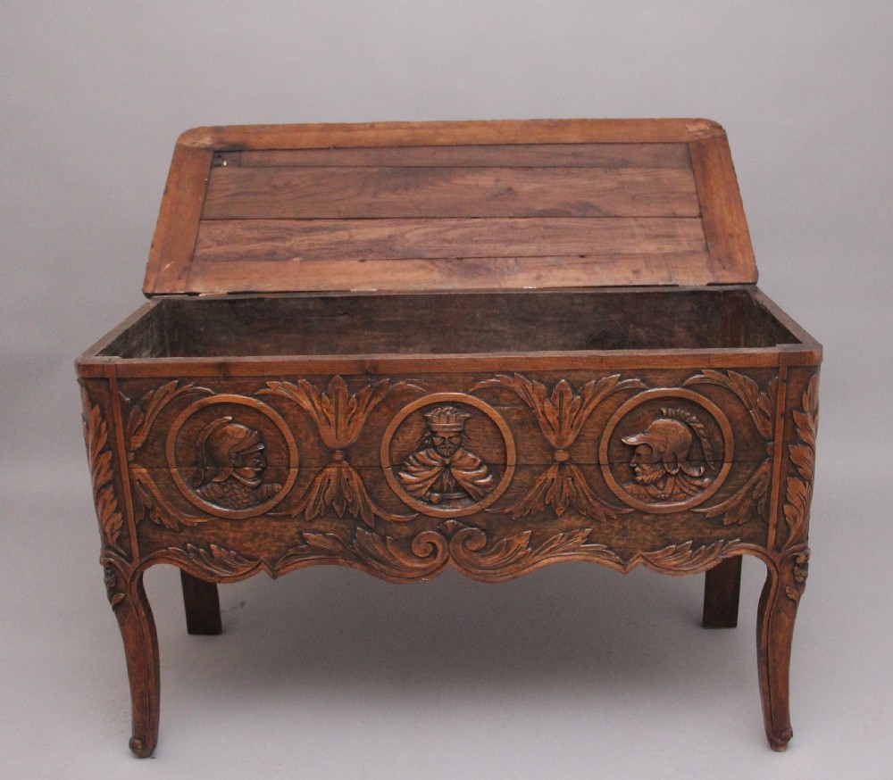 An early 19th-century French carved oak coffer featuring three carved profile medallions, acanthus leaf relief work, a scalloped apron, and cabriole legs. View III