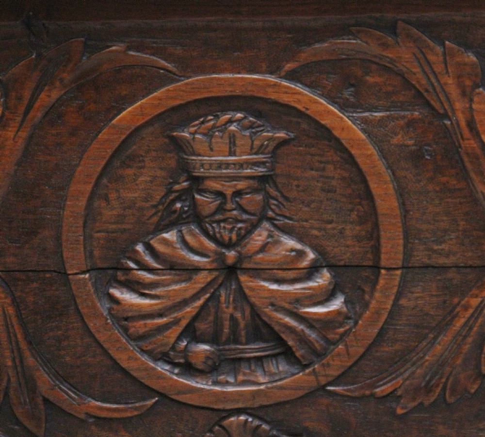 An early 19th-century French carved oak coffer featuring three carved profile medallions, acanthus leaf relief work, a scalloped apron, and cabriole legs. View VIII