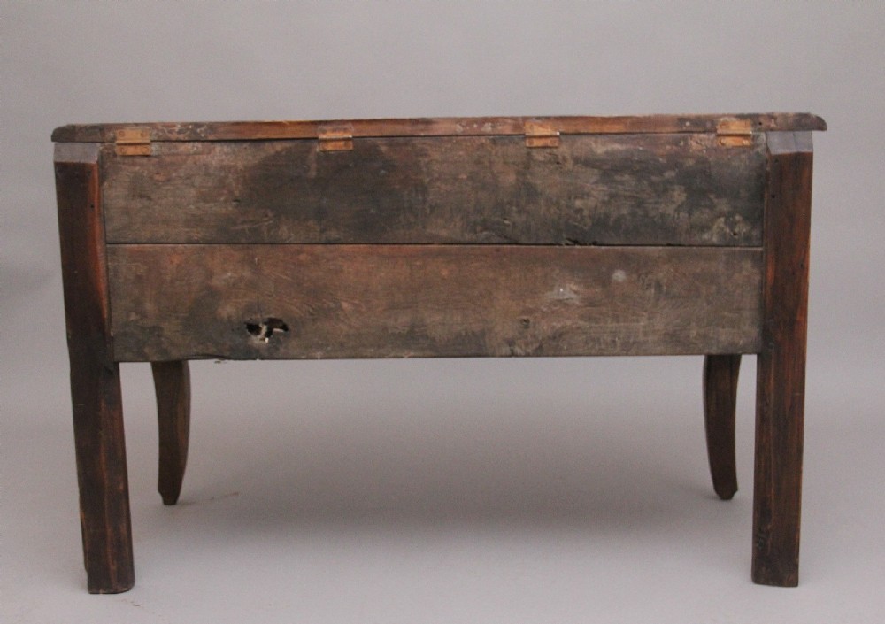 An early 19th-century French carved oak coffer featuring three carved profile medallions, acanthus leaf relief work, a scalloped apron, and cabriole legs. View XII