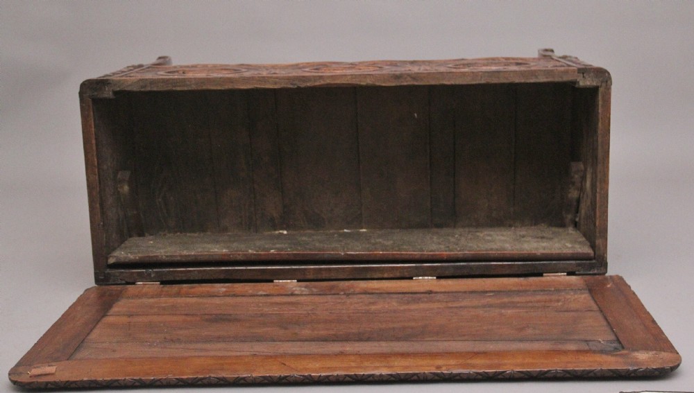 An early 19th-century French carved oak coffer featuring three carved profile medallions, acanthus leaf relief work, a scalloped apron, and cabriole legs. View XV