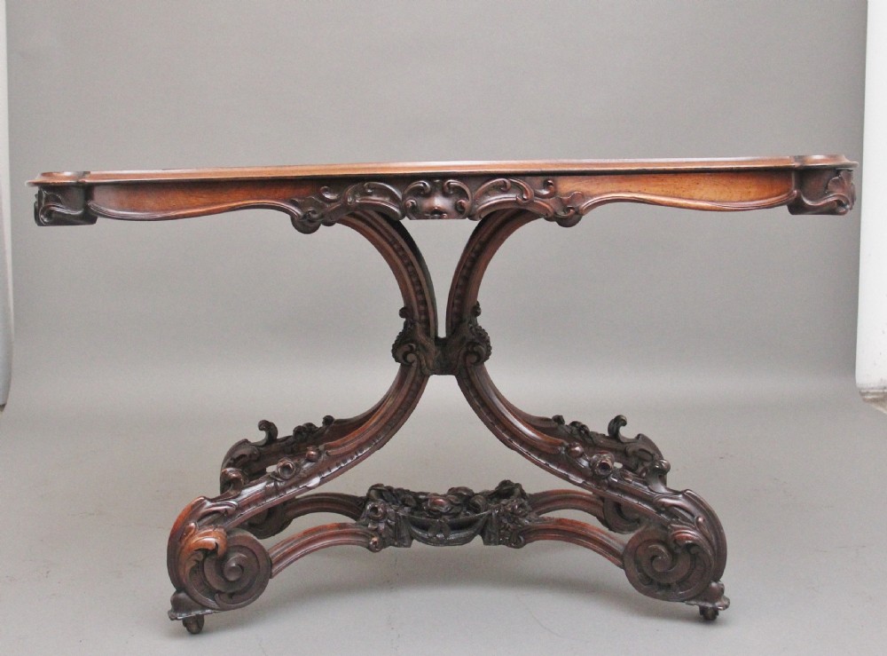 A 19th-century rosewood centre table featuring a serpentine top and carved C-scroll legs joined by a decorative stretcher. View II