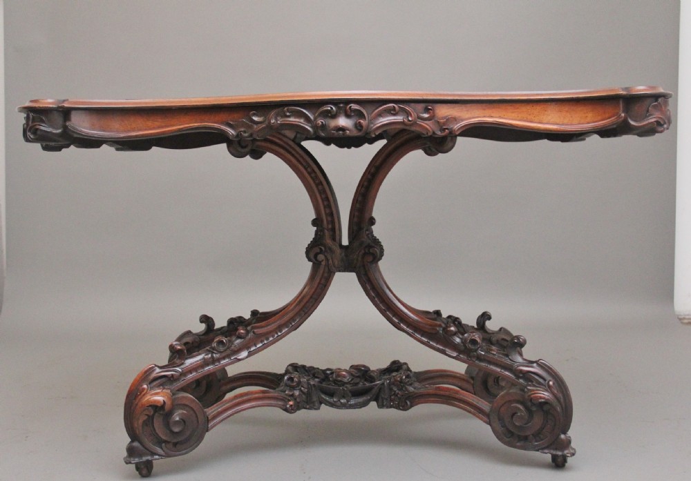 A 19th-century rosewood centre table featuring a serpentine top and carved C-scroll legs joined by a decorative stretcher. View III