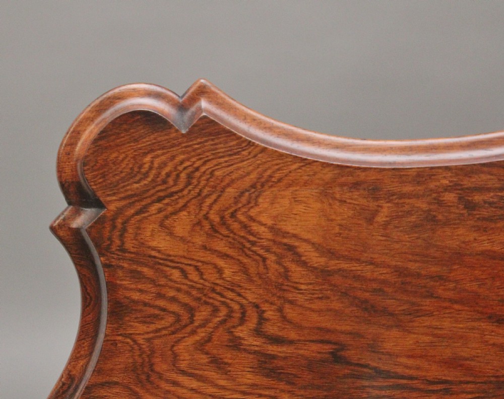A 19th-century rosewood centre table featuring a serpentine top and carved C-scroll legs joined by a decorative stretcher. View IX