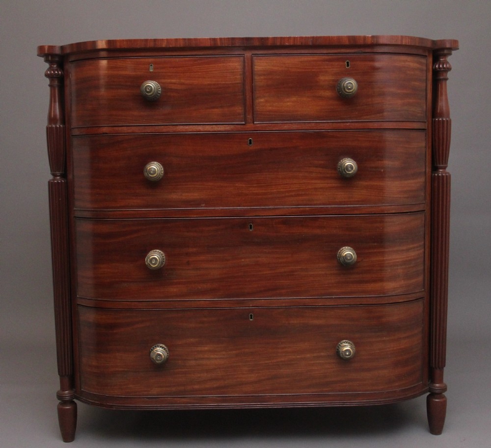 A 19th-century mahogany bowfront chest of drawers featuring two short over three long drawers flanked by reeded side columns.