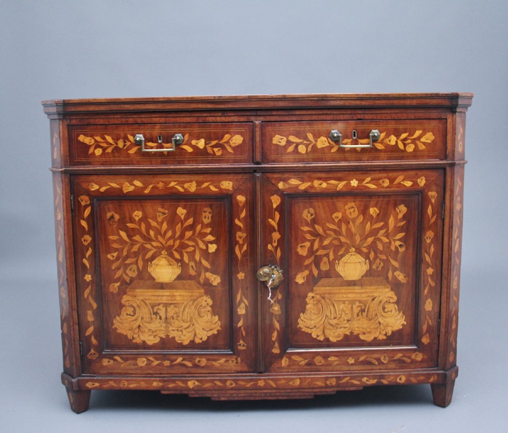 An early 19th-century Dutch travelling cabinet featuring floral fruitwood marquetry inlays, two upper drawers, two panelled doors, and side drop handles. View II