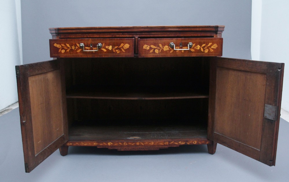 An early 19th-century Dutch travelling cabinet featuring floral fruitwood marquetry inlays, two upper drawers, two panelled doors, and side drop handles. View VI