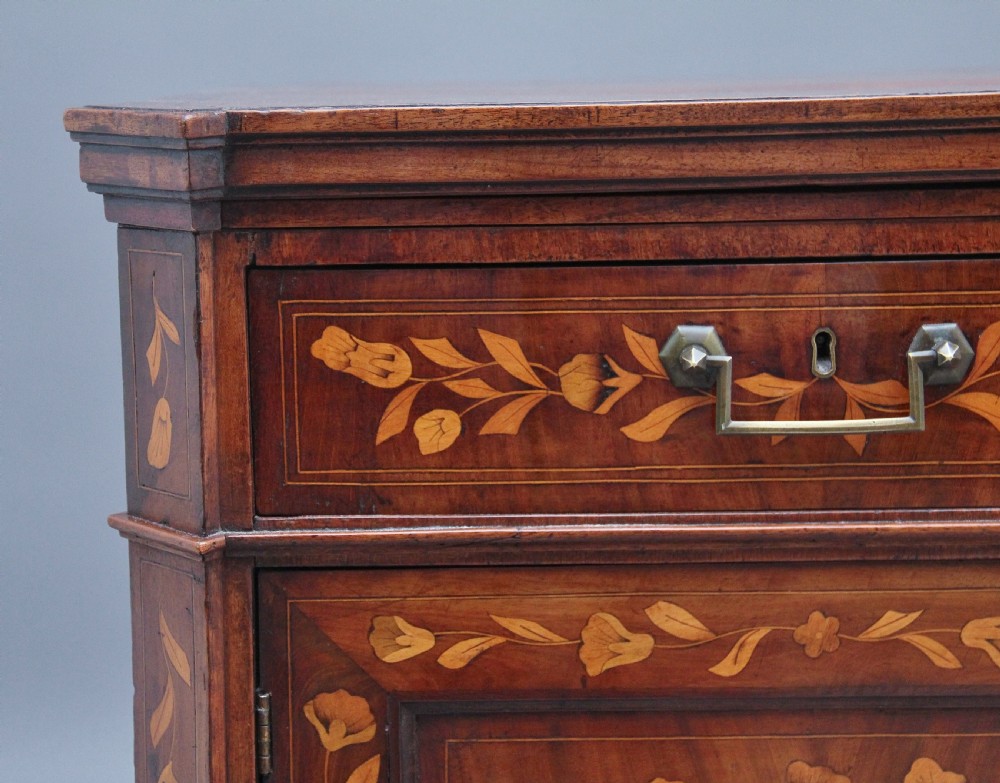 An early 19th-century Dutch travelling cabinet featuring floral fruitwood marquetry inlays, two upper drawers, two panelled doors, and side drop handles. View XIX