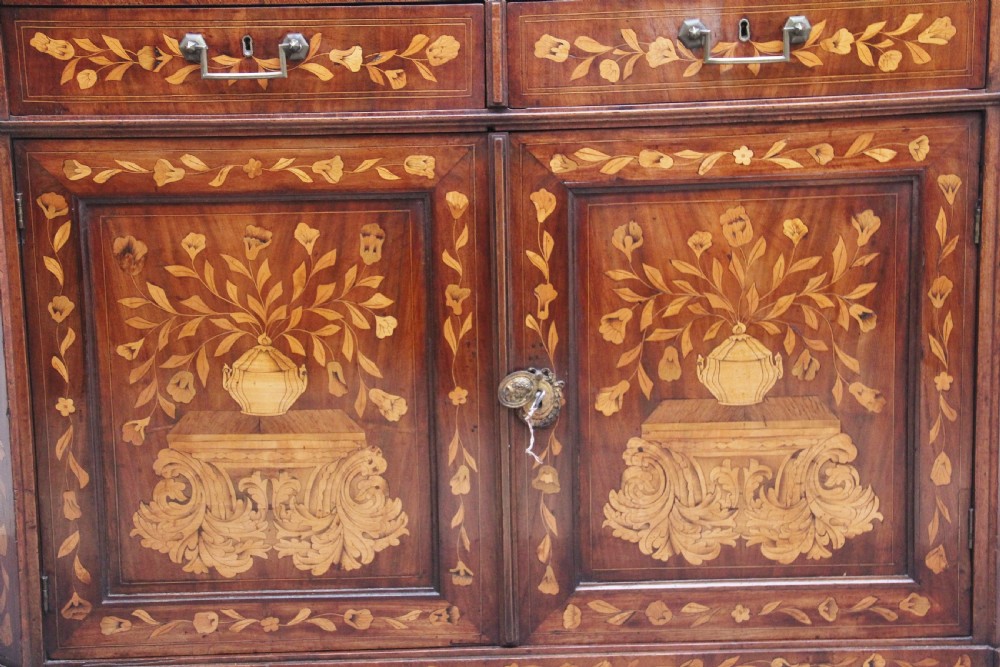 An early 19th-century Dutch travelling cabinet featuring floral fruitwood marquetry inlays, two upper drawers, two panelled doors, and side drop handles. View XX