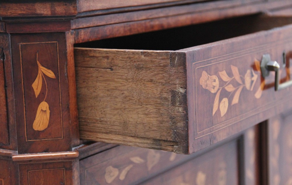 An early 19th-century Dutch travelling cabinet featuring floral fruitwood marquetry inlays, two upper drawers, two panelled doors, and side drop handles. View XXI