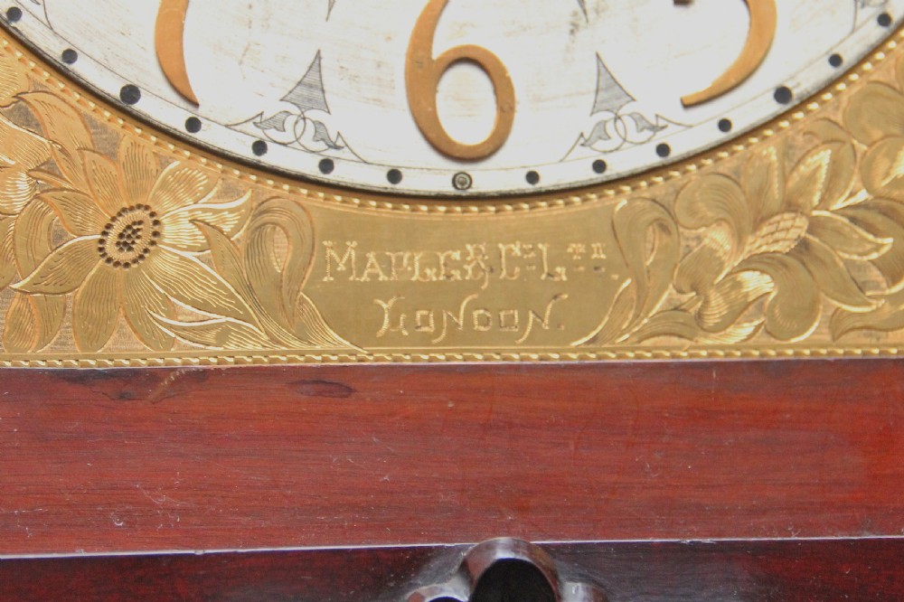 An early 20th-century carved dark mahogany longcase clock featuring an ornate pediment, carved trunk door, and etched brass dial. View VIII