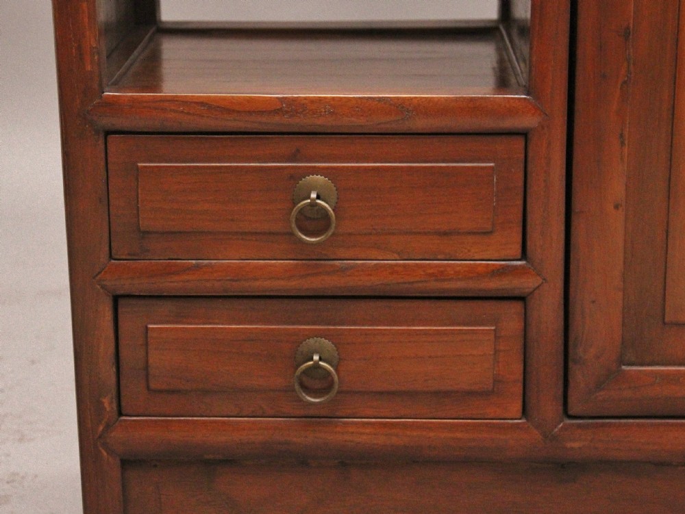 An early 20th-century Chinese hardwood duobaoge cabinet featuring asymmetrical open shelving, geometric side cut-outs, and lower drawers with brass hardware. View IX